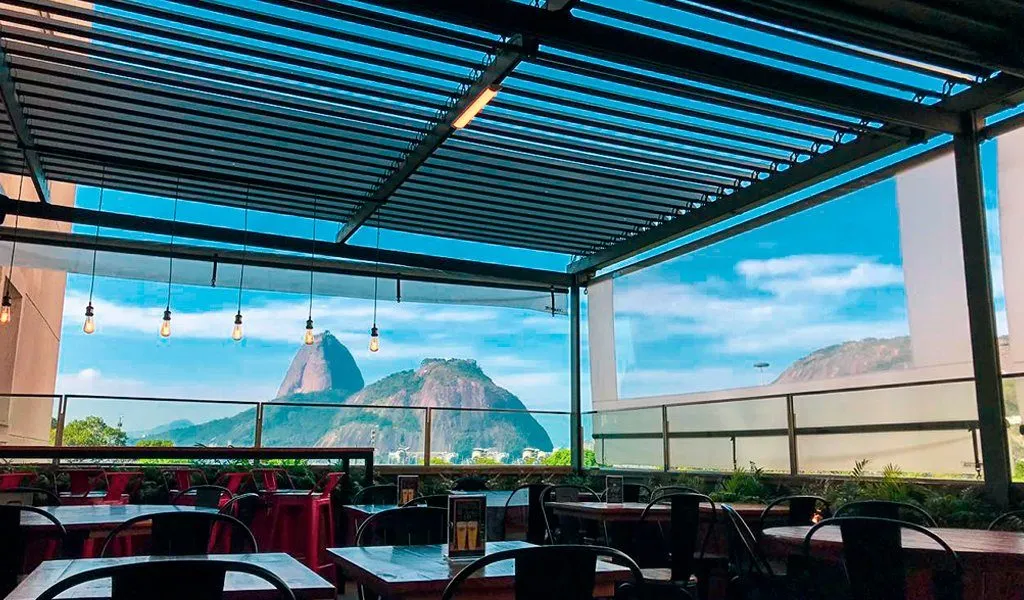 Cobertura retrátil aberta em área externa de restaurante com vista panorâmica